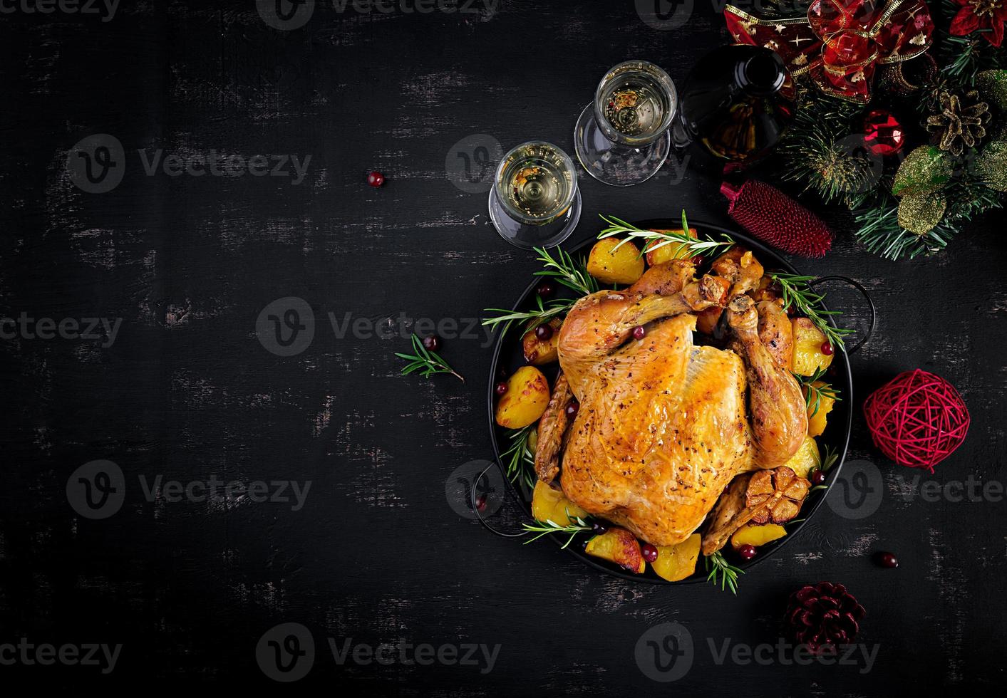 Baked turkey or chicken. The Christmas table is served with a turkey, decorated with bright tinsel. Fried chicken. Table setting. Christmas dinner. Top view photo