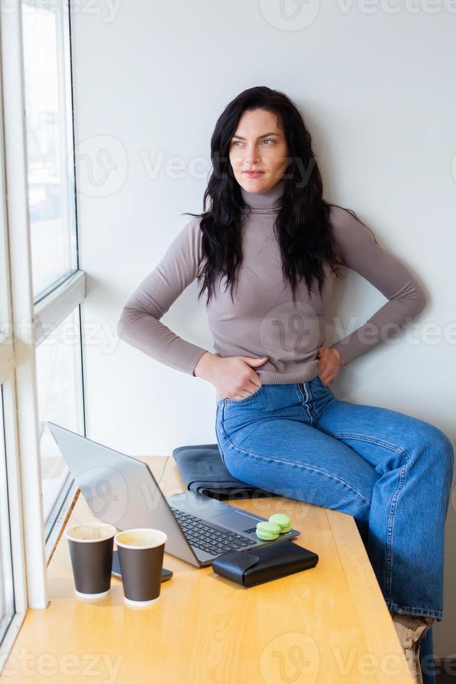 Beautiful businesswoman working on a laptop. Female freelancer connecting to internet via computer. Blogger or journalist writing new article. photo