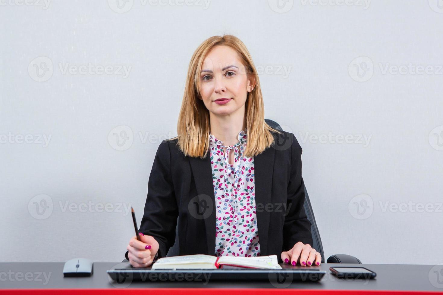 Beautiful businesswoman working on a laptop. Female freelancer connecting to internet via computer. Blogger or journalist writing new article. photo