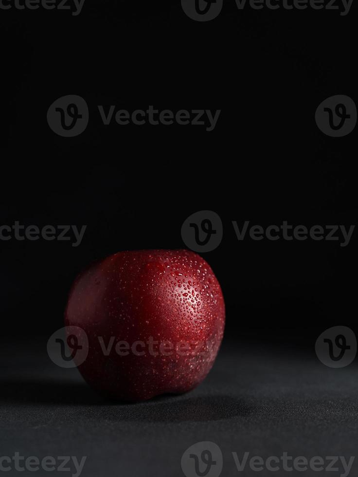 Close up of Red juicy Apple with drops of water on a Black Background. Isolate. Copy space photo