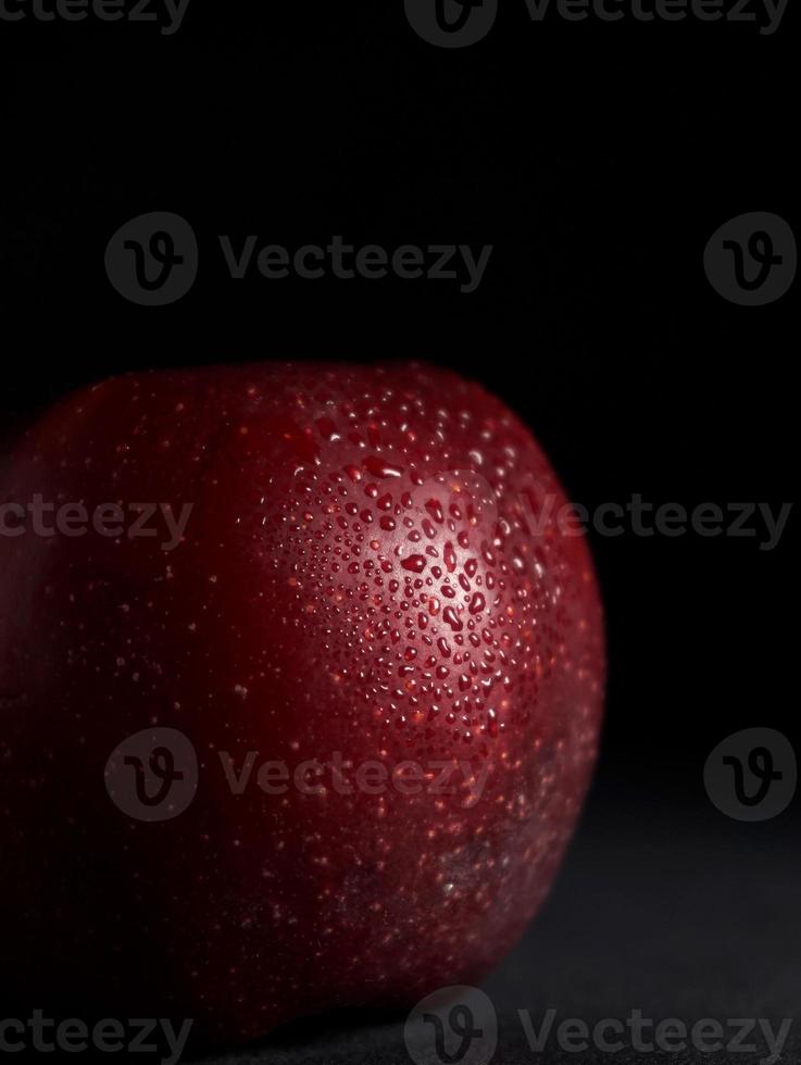 rojo jugoso manzana con gotas de agua en un negro antecedentes. aislar. Copiar espacio. cerca arriba foto