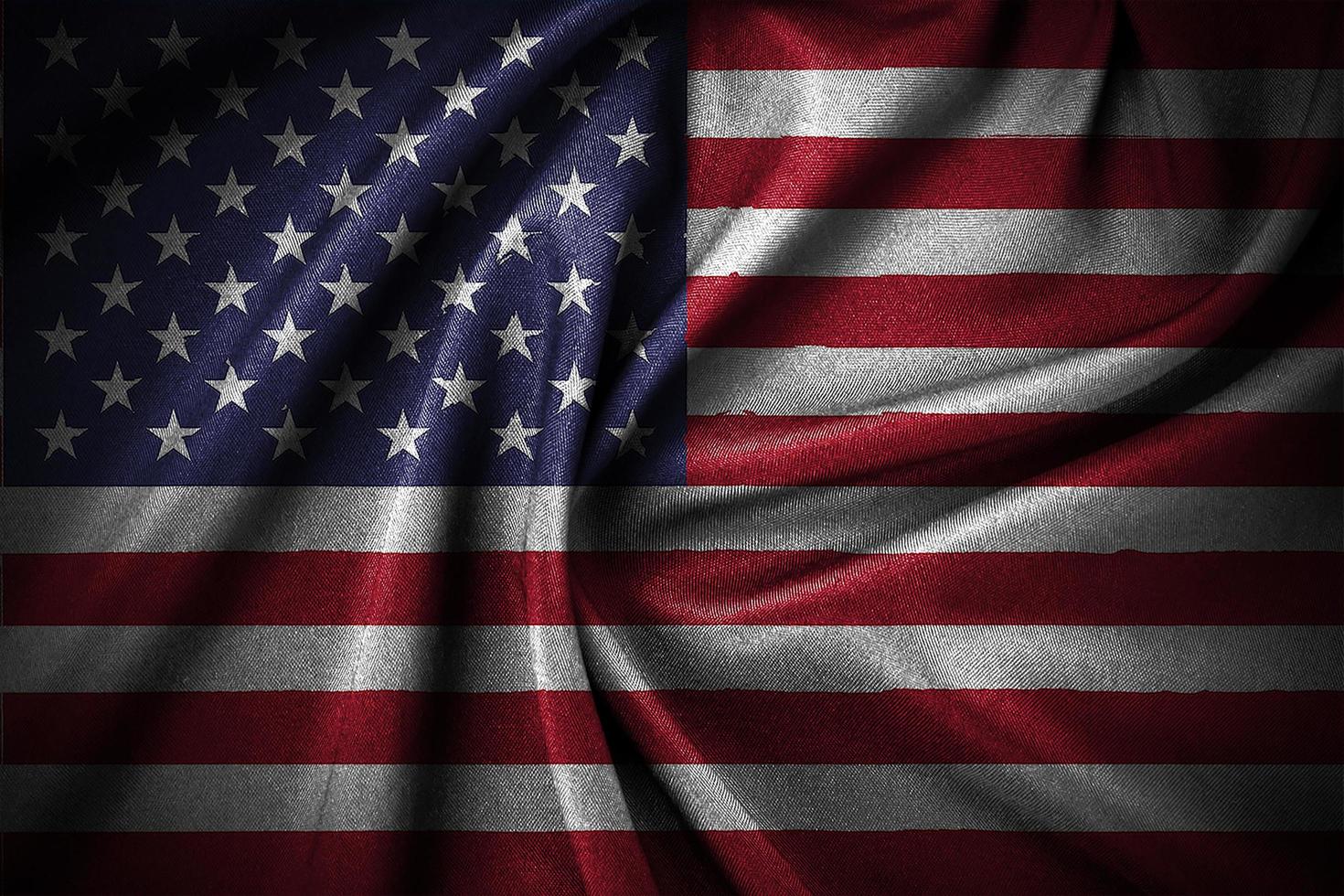 Closeup of grunge American flag wavy on dark background photo