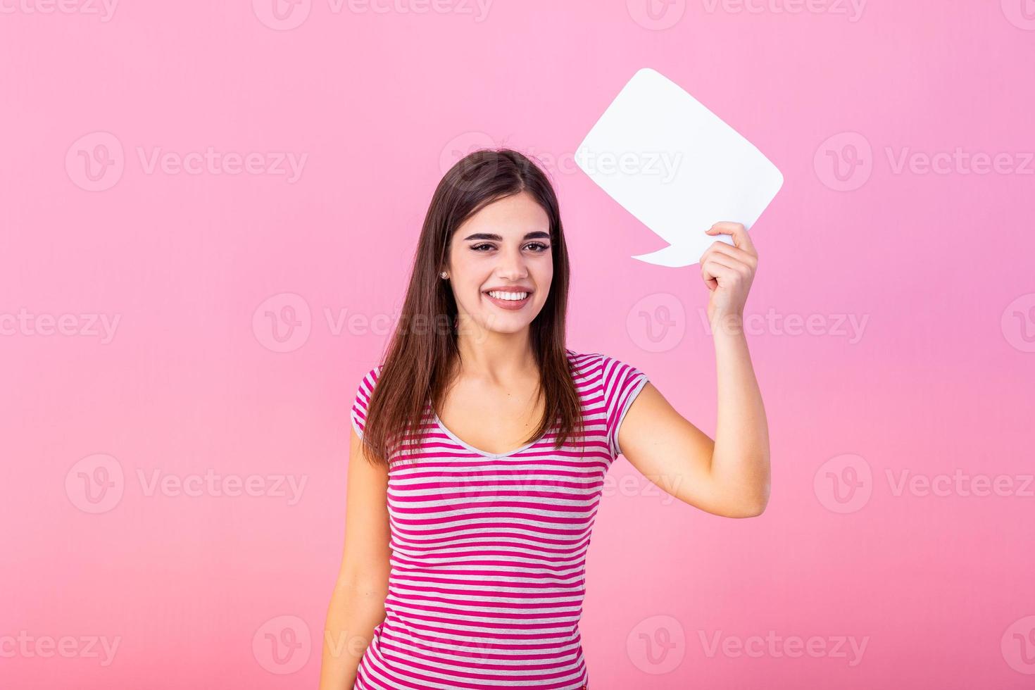 mujer demostración firmar habla burbuja bandera mirando contento emocionado en rosado antecedentes. hermosa joven alegre modelo en rosado antecedentes teniendo idea. foto