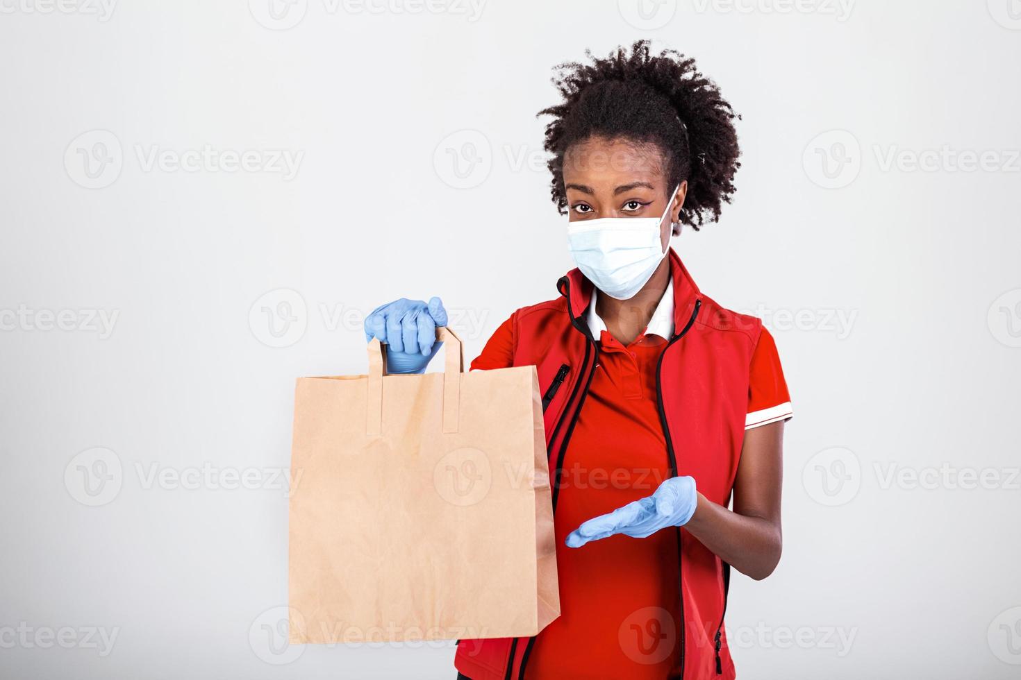 Delivery woman employee in red t-shirt uniform mask glove hold craft paper bag with food isolated on white background studio Service quarantine pandemic coronavirus virus 2019-ncov concept photo