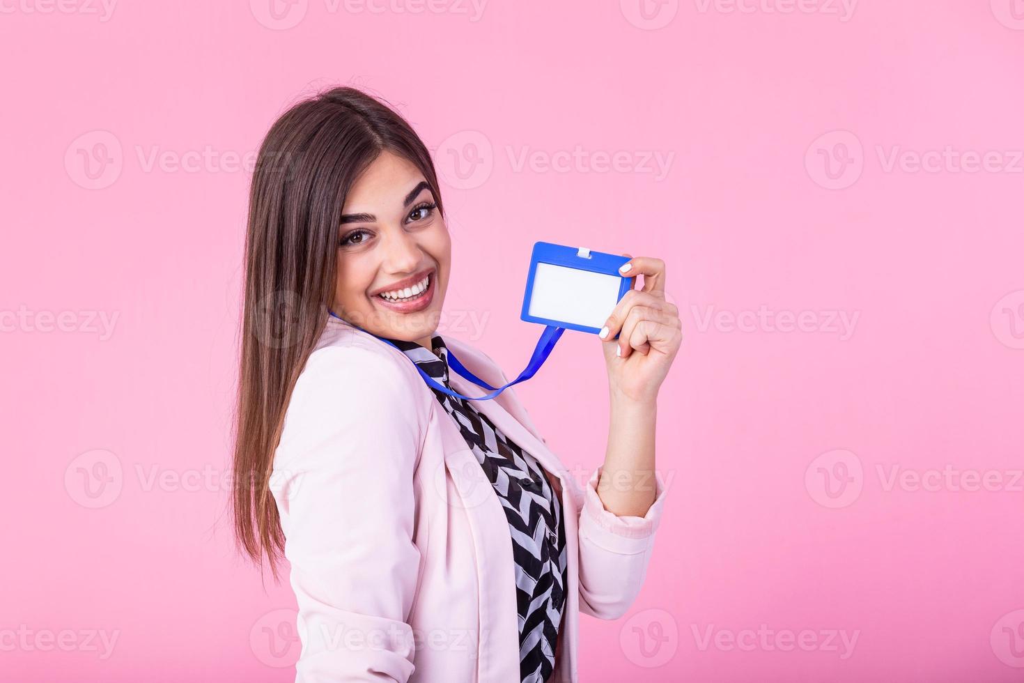 young attractive businesswoman holds her badge and pointing it to camera, isolated on background. Id template photo