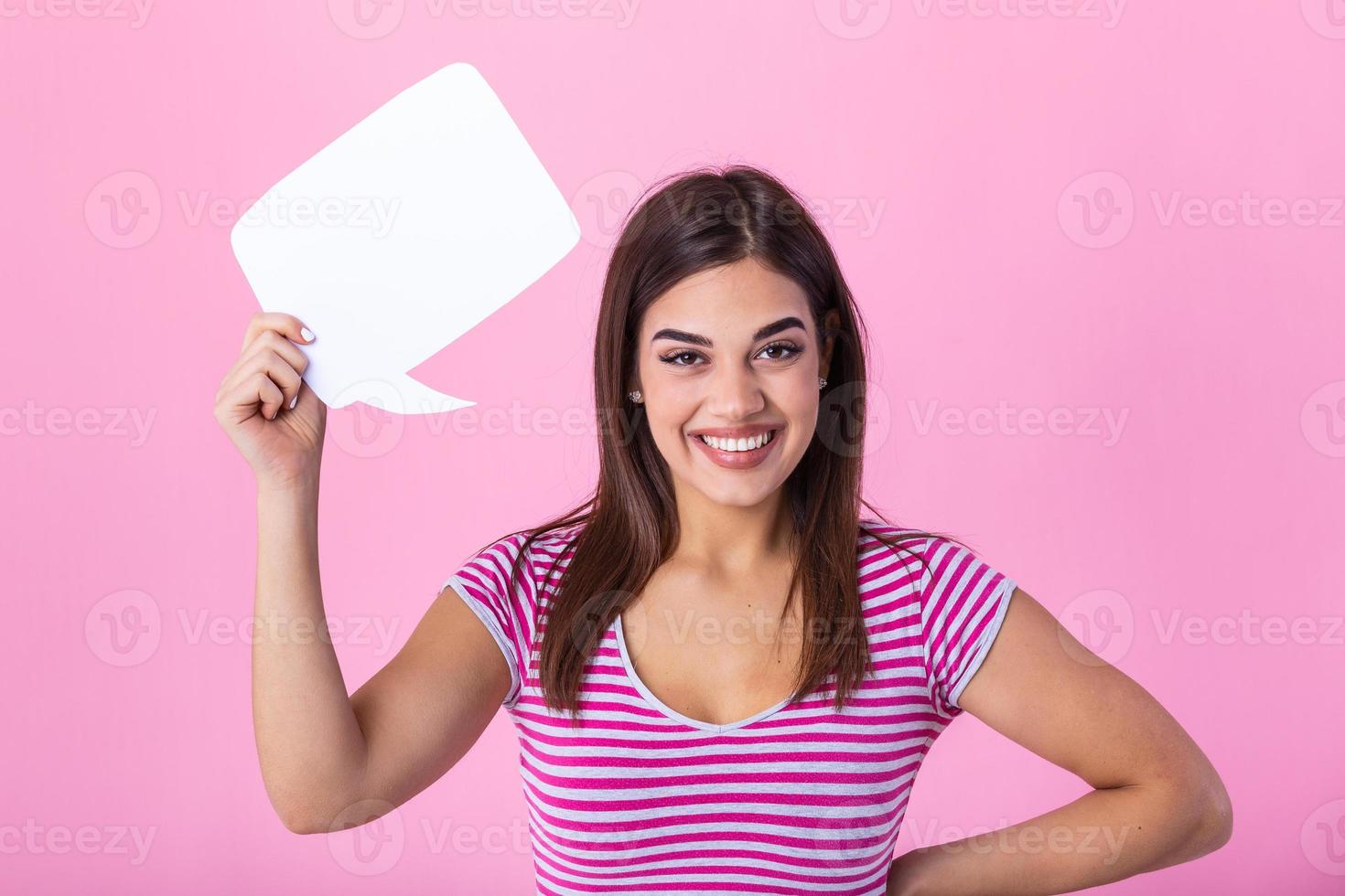 Portrait of a happy young beautiful woman holding empty speech bubble isolated over pink background photo