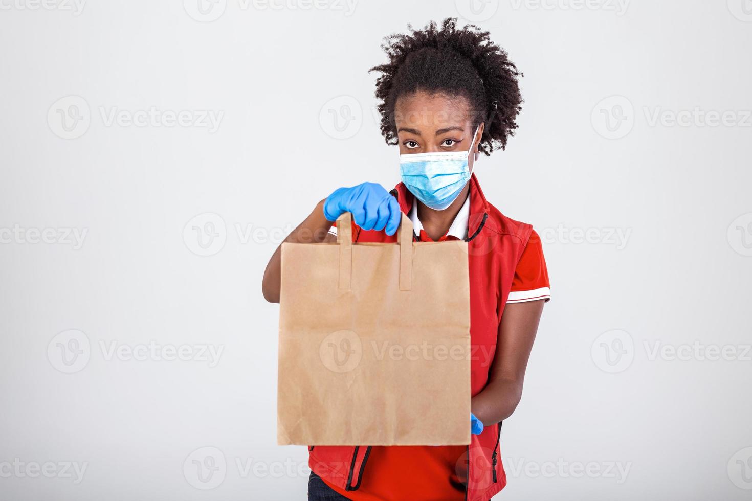 Delivery woman holding paper bag in medical rubber gloves and maskshowing thumb up. copy space. Fast and free Delivery transport . Online shopping and Express delivery . Quarantine photo