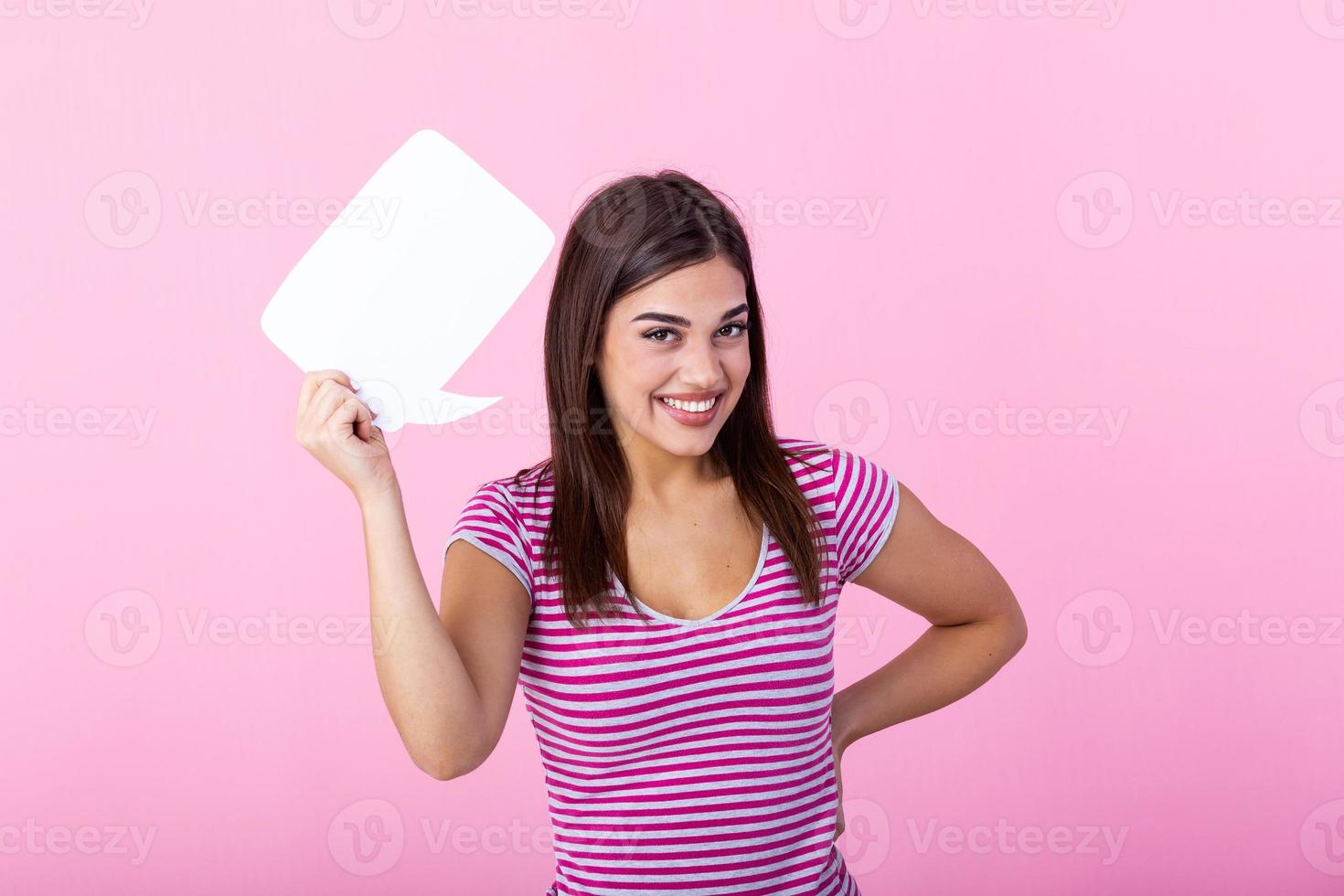 Hey, great idea. Happy pensive beautiful girl looking at blank speech bubble, copy space. Beautiful young joyful model on pink background having idea. photo