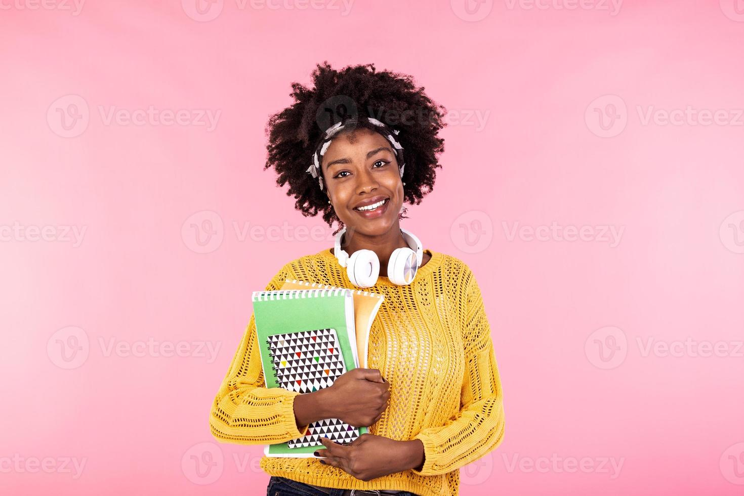 Young female student in glasses holding books in hand isolated on pink background portrait, casual daily lifestyle student holding notebooks smiling photo