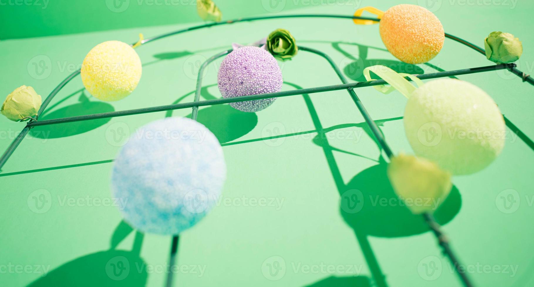 Hanging easter colorful eggs with a shadow on a green background photo