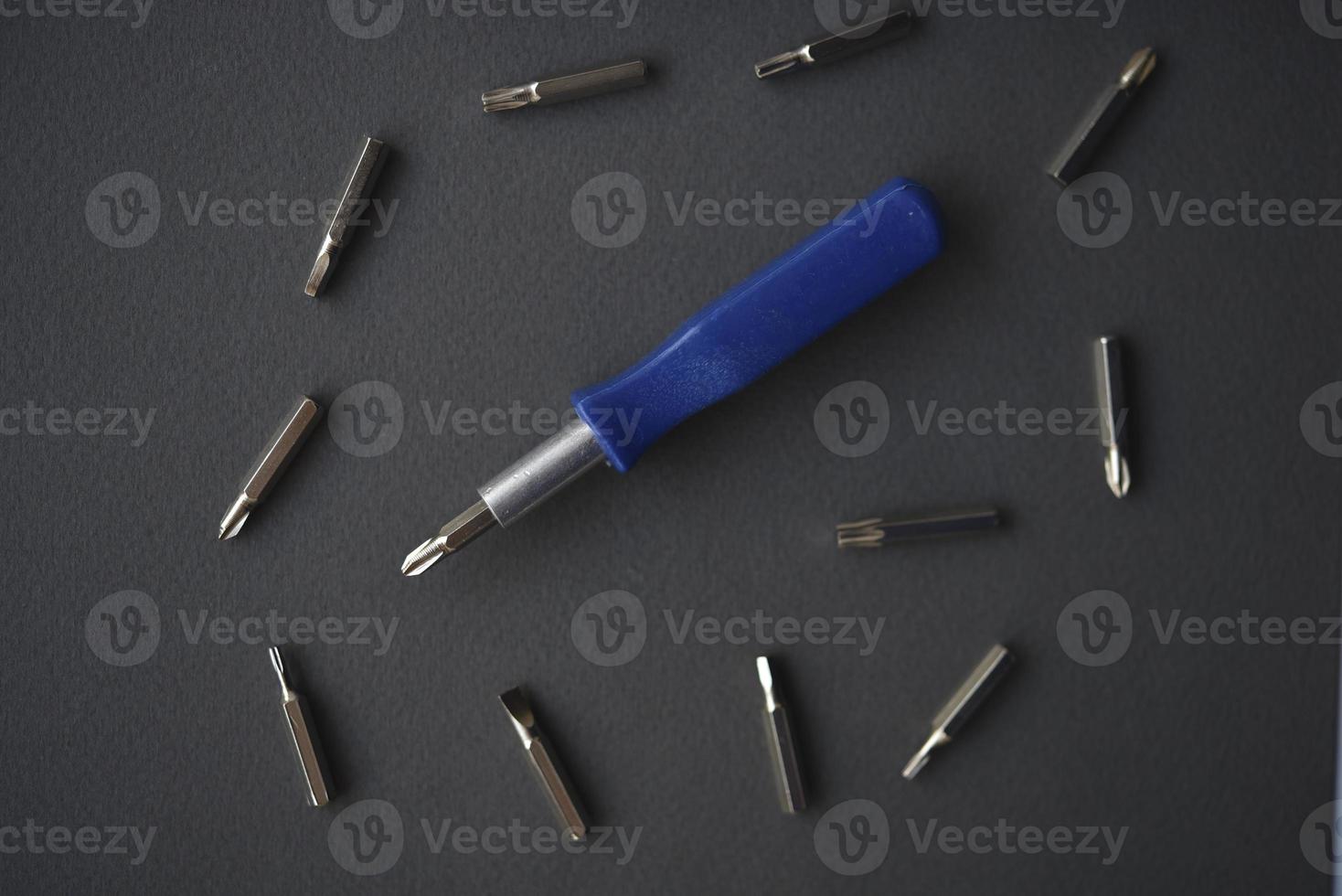 Replaceable nozzles for a screwdriver. Blue screwdriver with attachments. photo