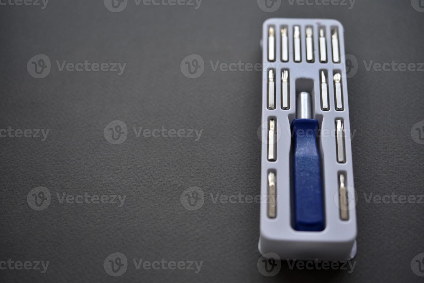 A set of screwdrivers with nozzles on a gray background. Replaceable nozzles for a screwdriver. photo