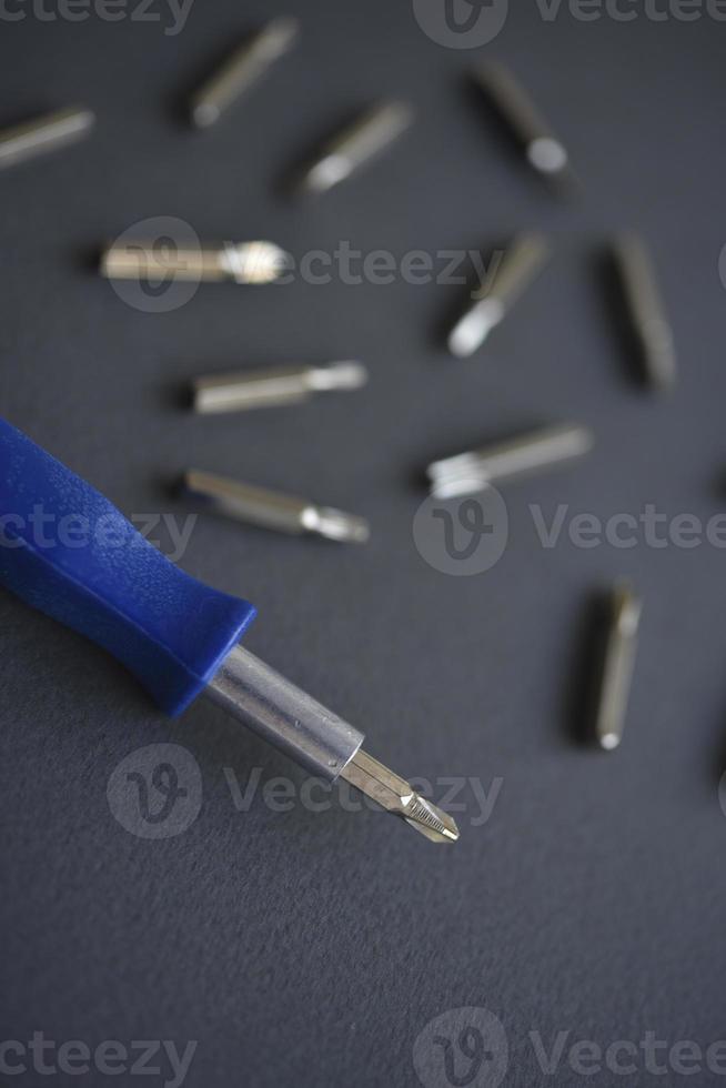 Replaceable nozzles for a screwdriver. Blue screwdriver with attachments. photo