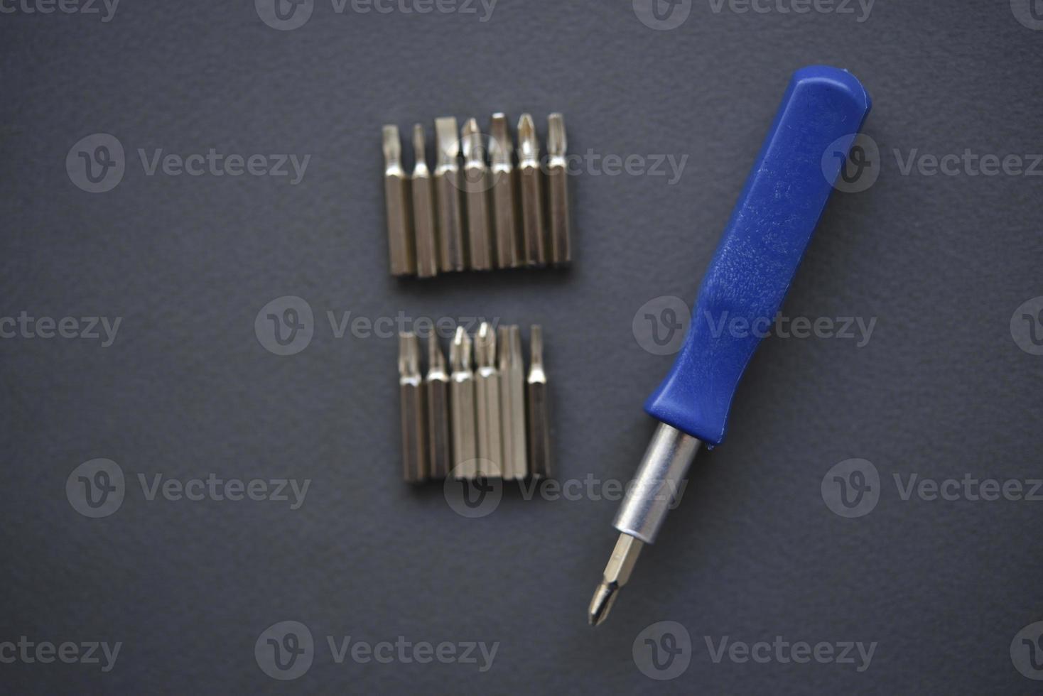 Replaceable nozzles for a screwdriver. Blue screwdriver with attachments. photo