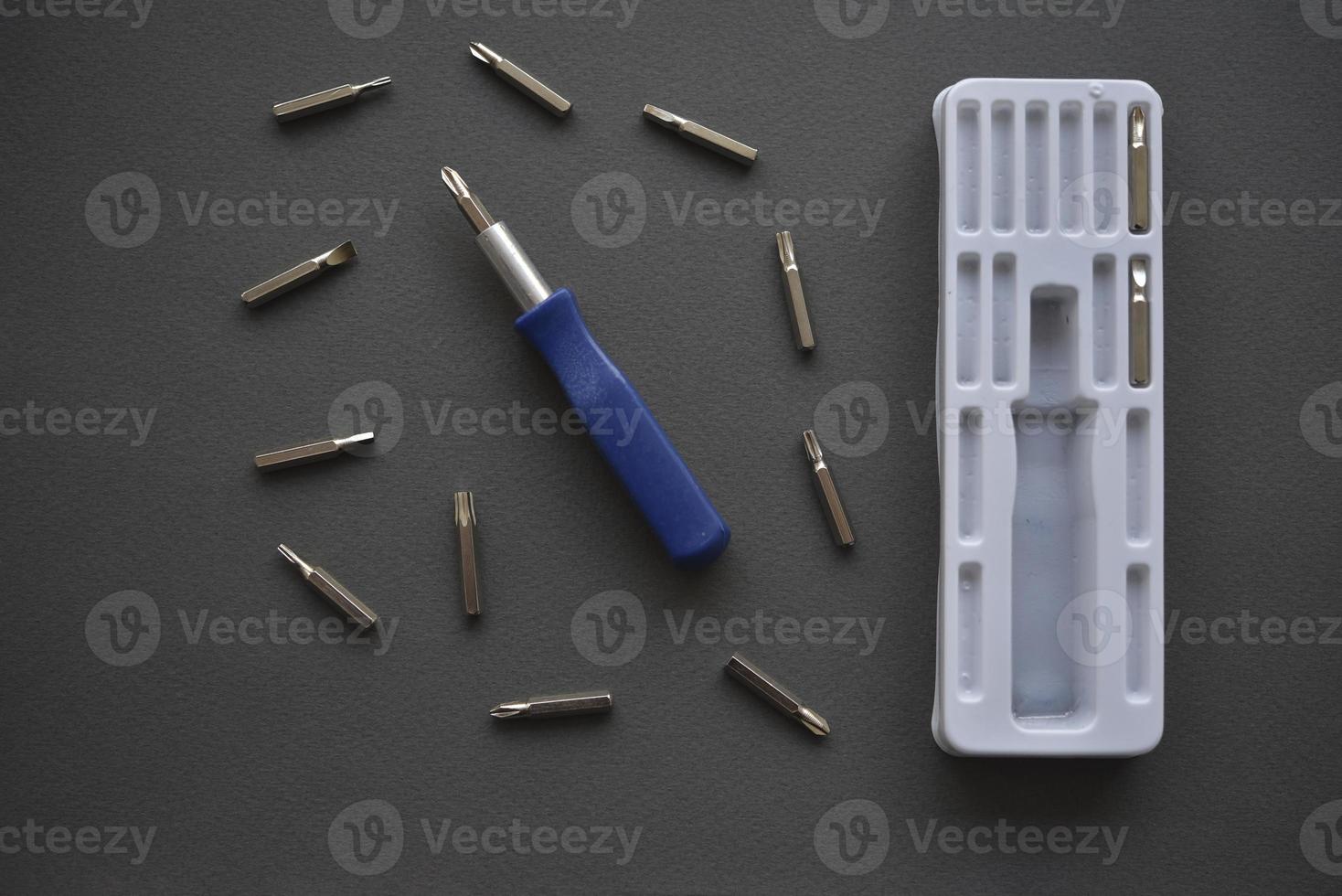 A set of screwdrivers with nozzles on a gray background. Replaceable nozzles for a screwdriver. photo