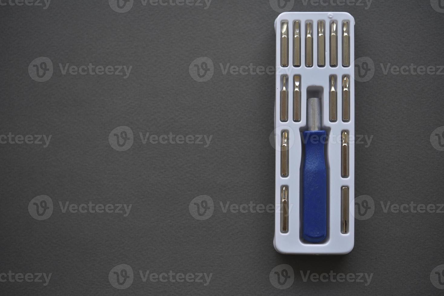 A set of screwdrivers with nozzles on a gray background. Replaceable nozzles for a screwdriver. photo