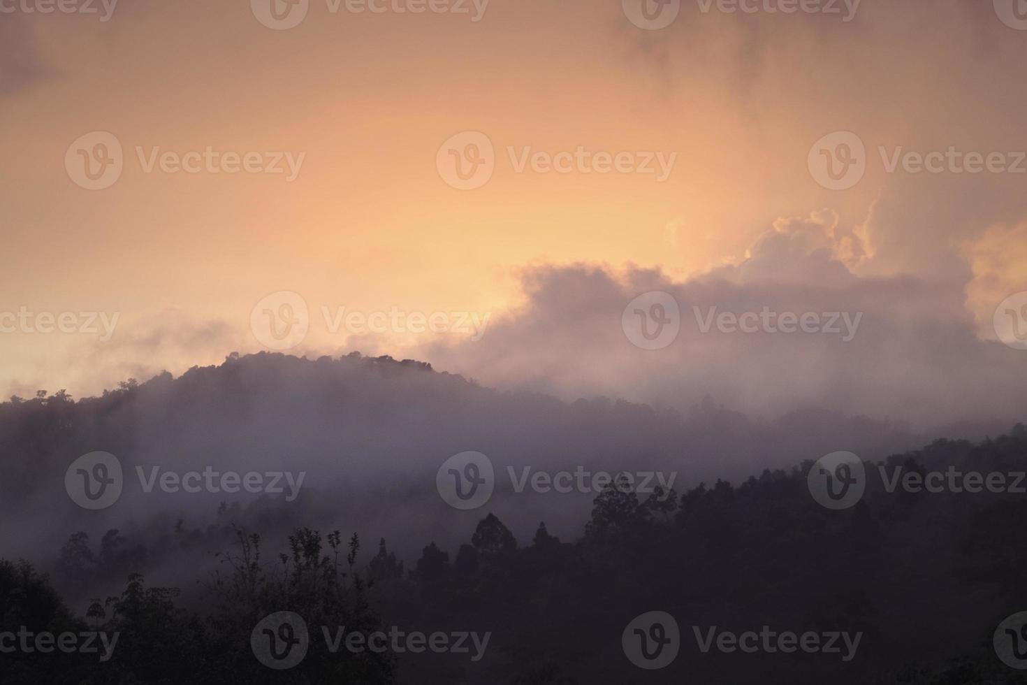 mist covered mountain at sunrise photo