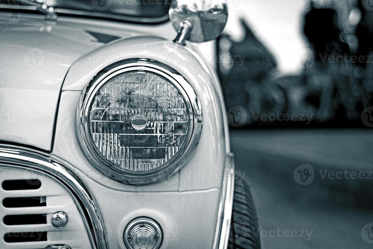 close up head light classic car and road photo