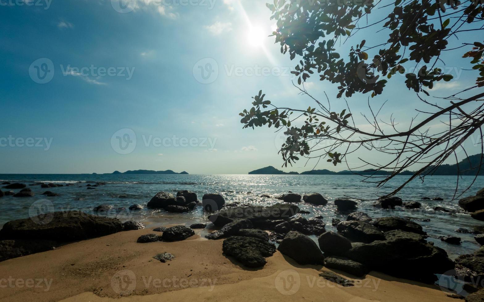 playa soleado día paisaje con luz de sol y rocas foto