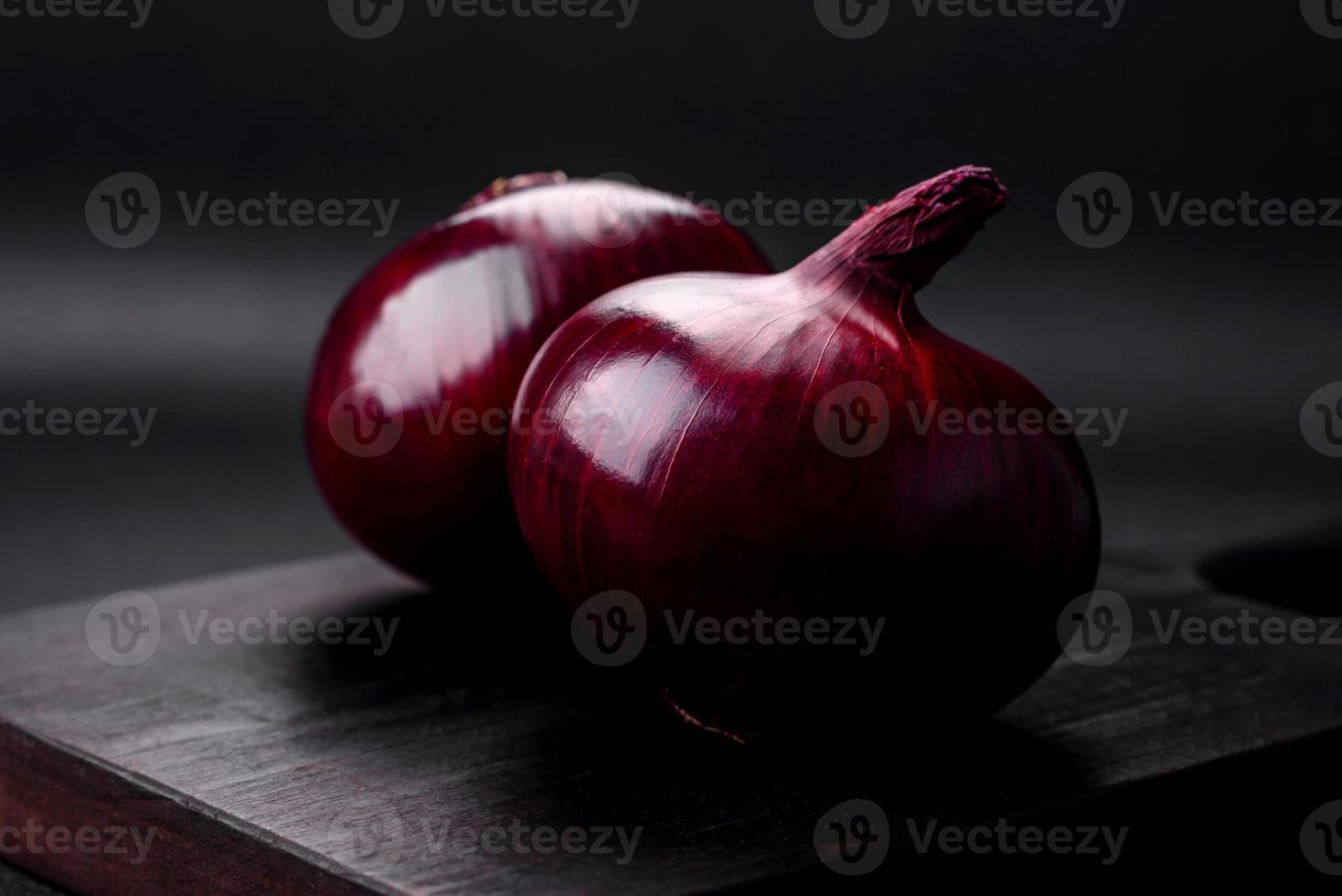 Fresh raw red onion on dark textured concrete background photo