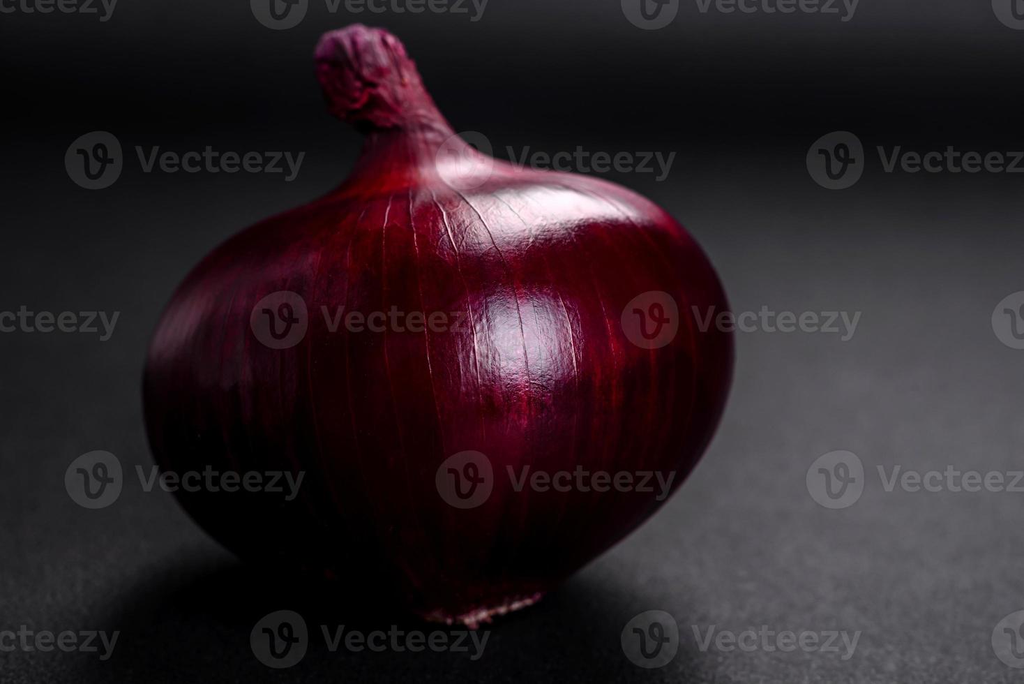 Fresco crudo rojo cebolla en oscuro texturizado hormigón antecedentes foto