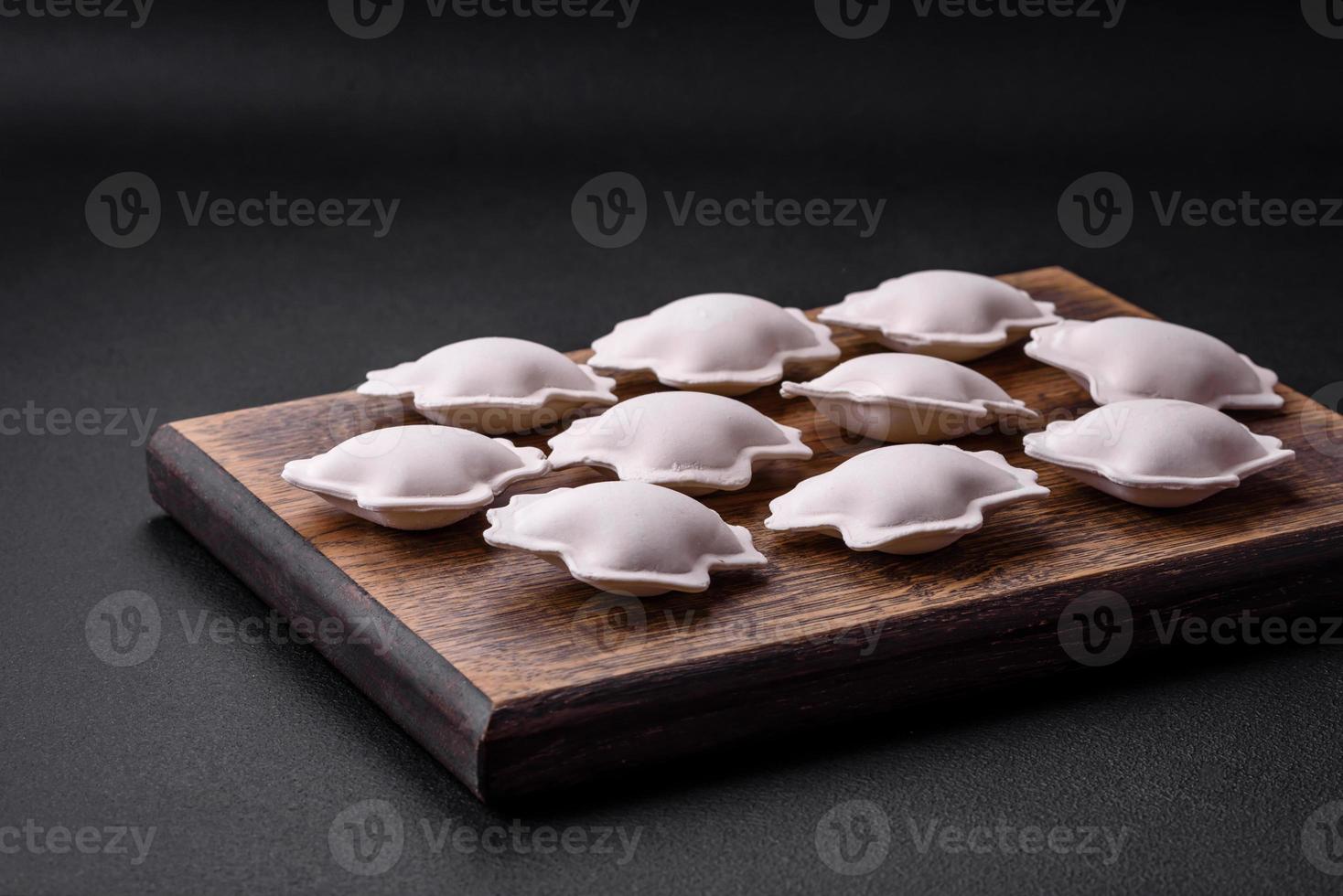 crudo congelado relleno empanadillas en un de madera corte tablero foto
