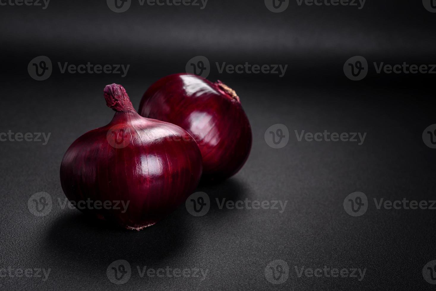 Fresco crudo rojo cebolla en oscuro texturizado hormigón antecedentes foto