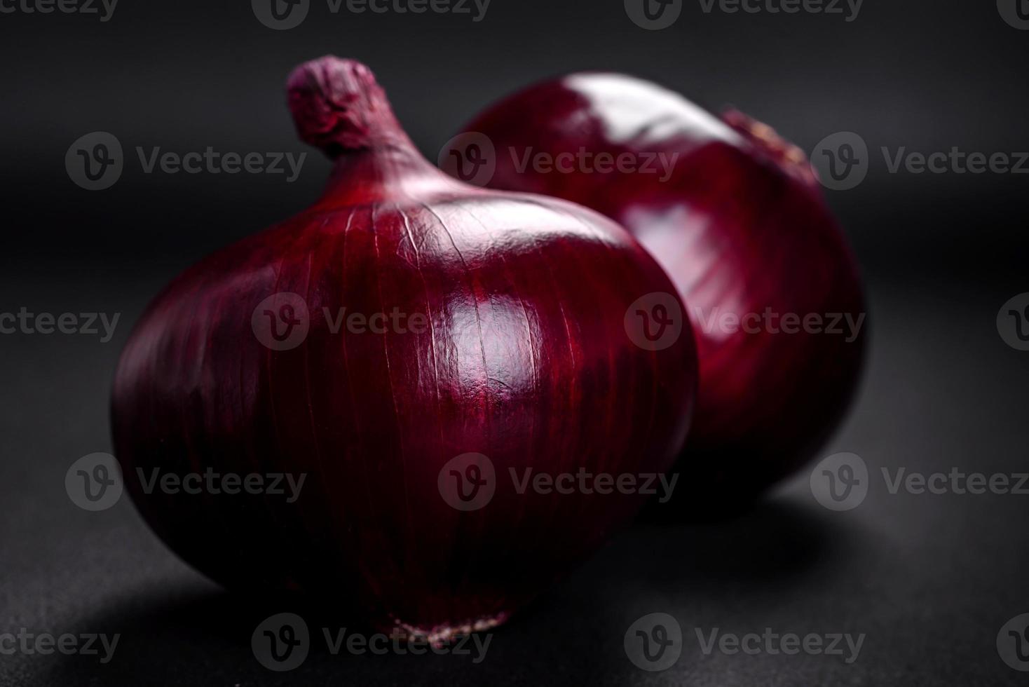 Fresh raw red onion on dark textured concrete background photo