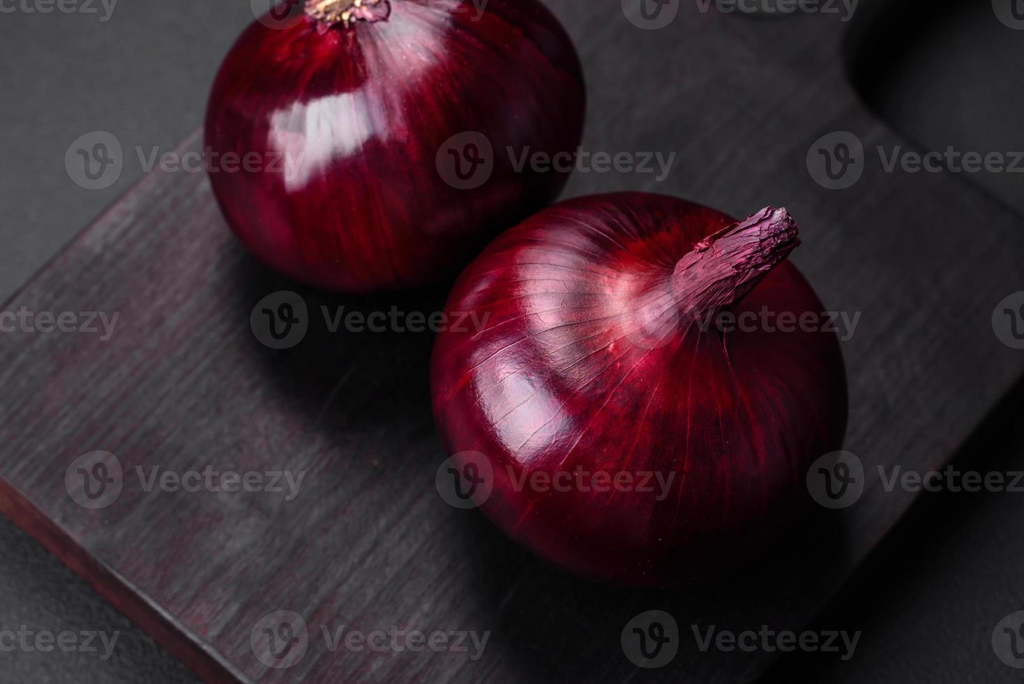 Fresh raw red onion on dark textured concrete background photo