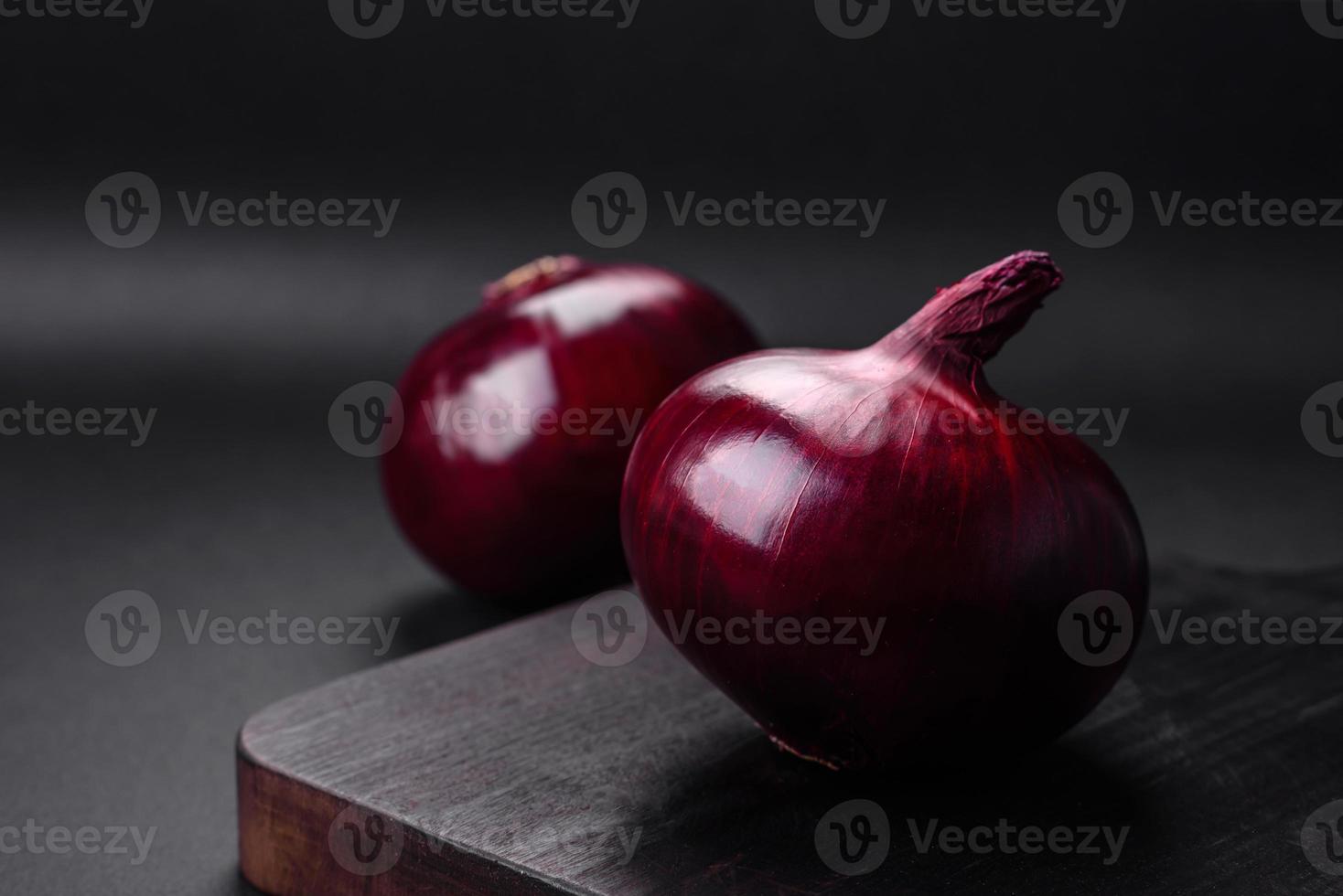 Fresh raw red onion on dark textured concrete background photo