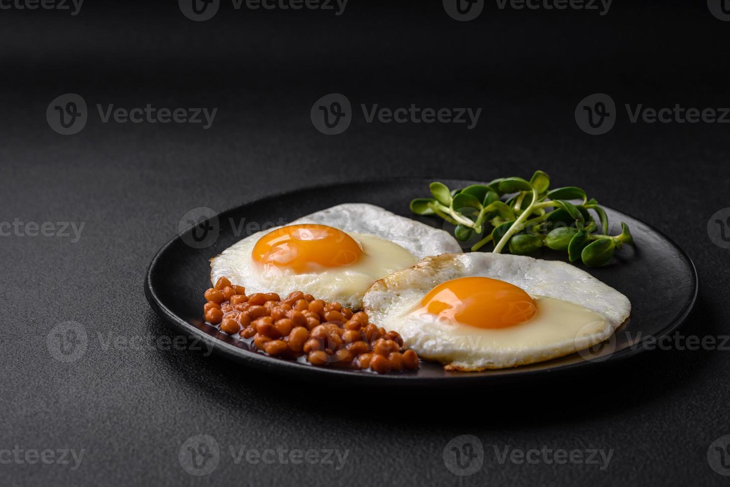 delicioso abundante desayuno consistente de dos frito huevos, Enlatado lentejas y microgreens foto