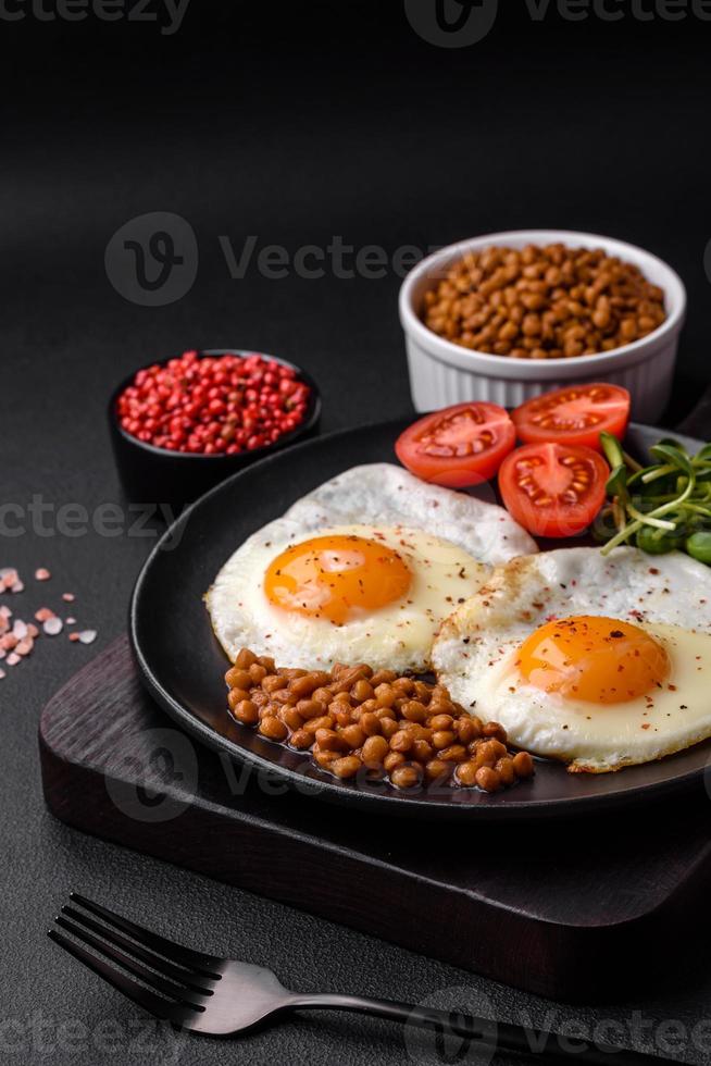 Delicious hearty breakfast consisting of two fried eggs, canned lentils and microgreens photo