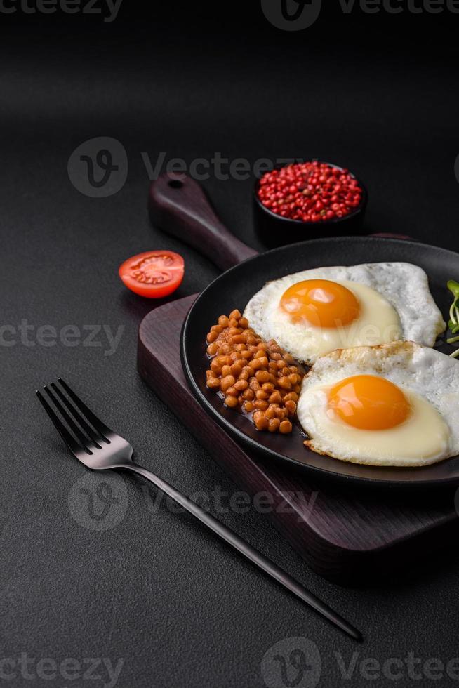 delicioso abundante desayuno consistente de dos frito huevos, Enlatado lentejas y microgreens foto