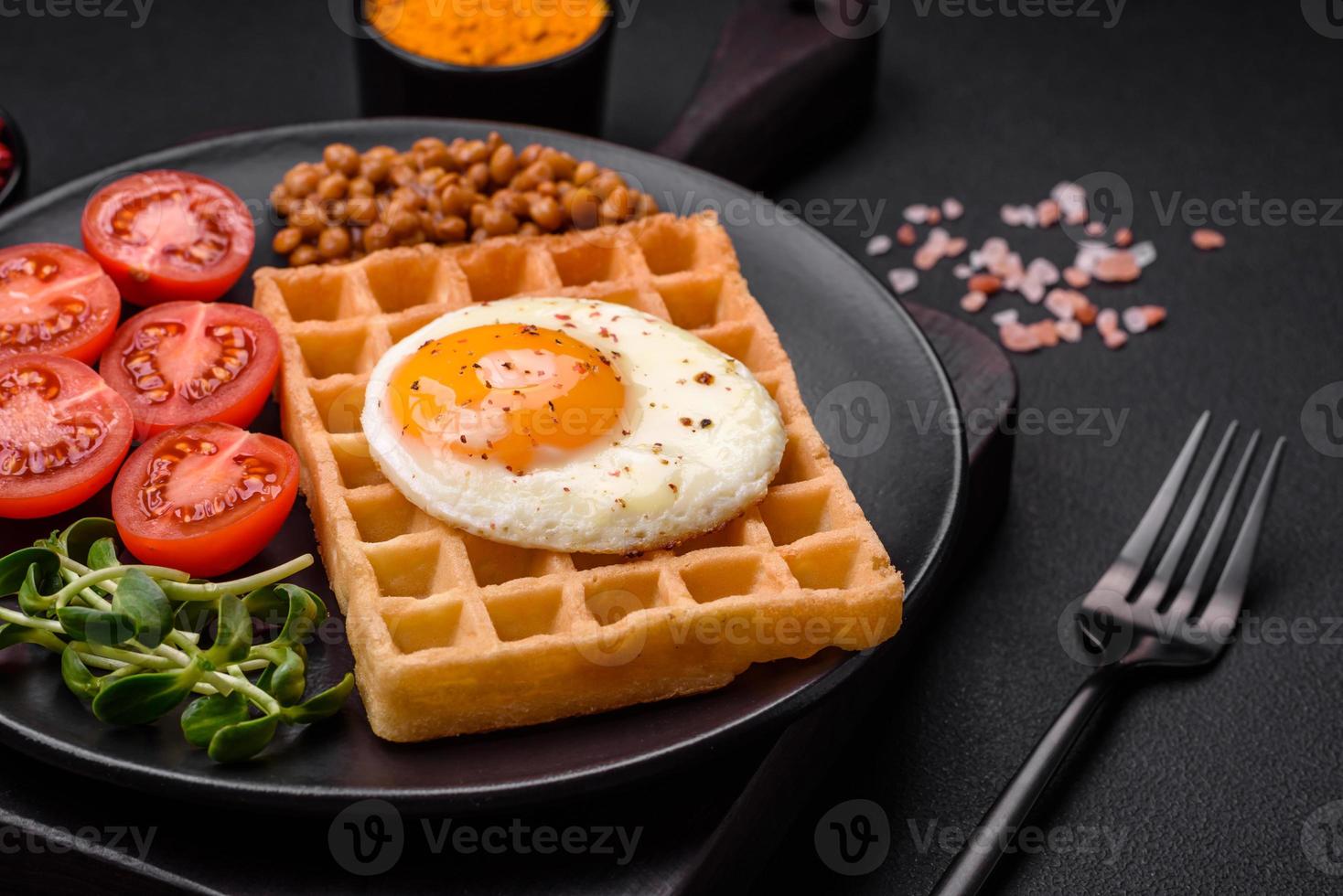 delicioso abundante desayuno consistente de un frito huevo, Belga gofre foto