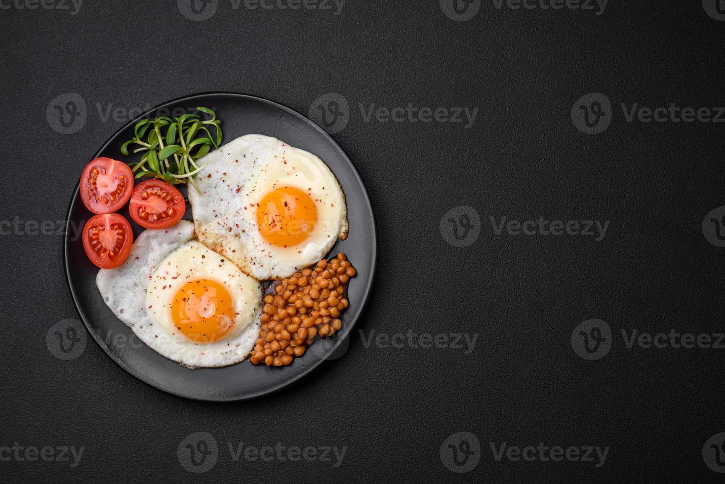 Delicious hearty breakfast consisting of two fried eggs, canned lentils and microgreens photo