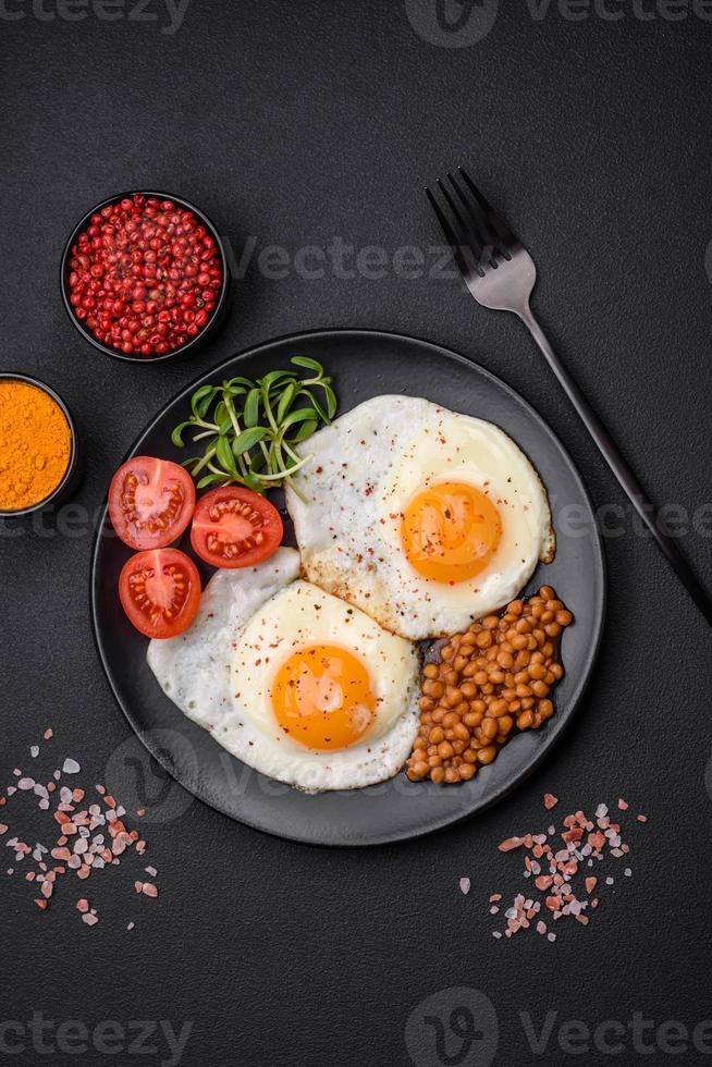 delicioso abundante desayuno consistente de dos frito huevos, Enlatado lentejas y microgreens foto