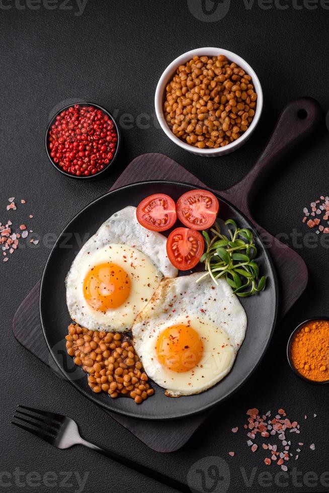 Delicious hearty breakfast consisting of two fried eggs, canned lentils and microgreens photo