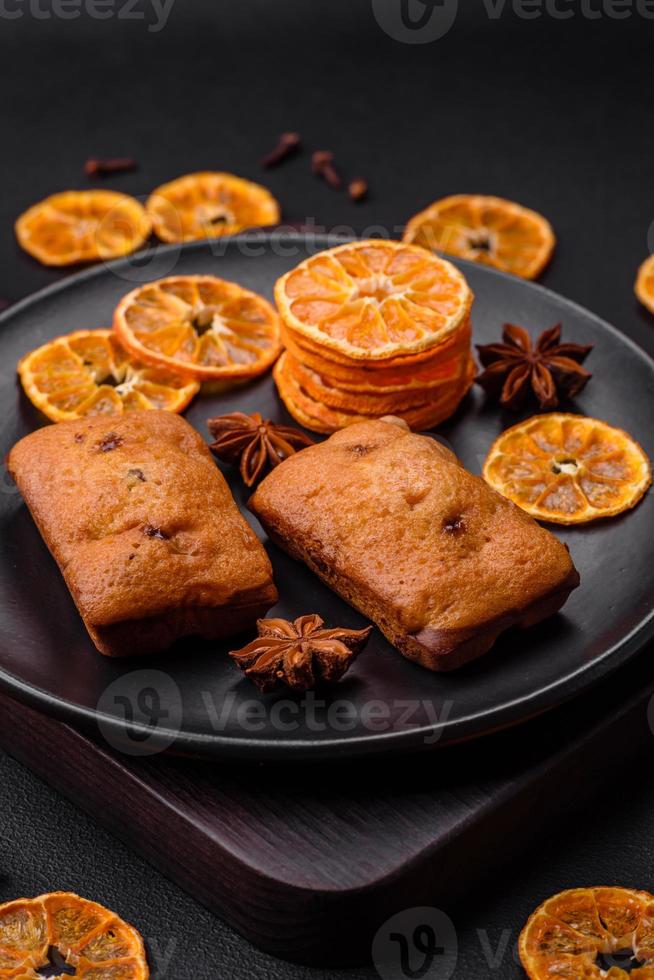 Delicious chocolate muffins and dried round shaped slices of tangerine photo