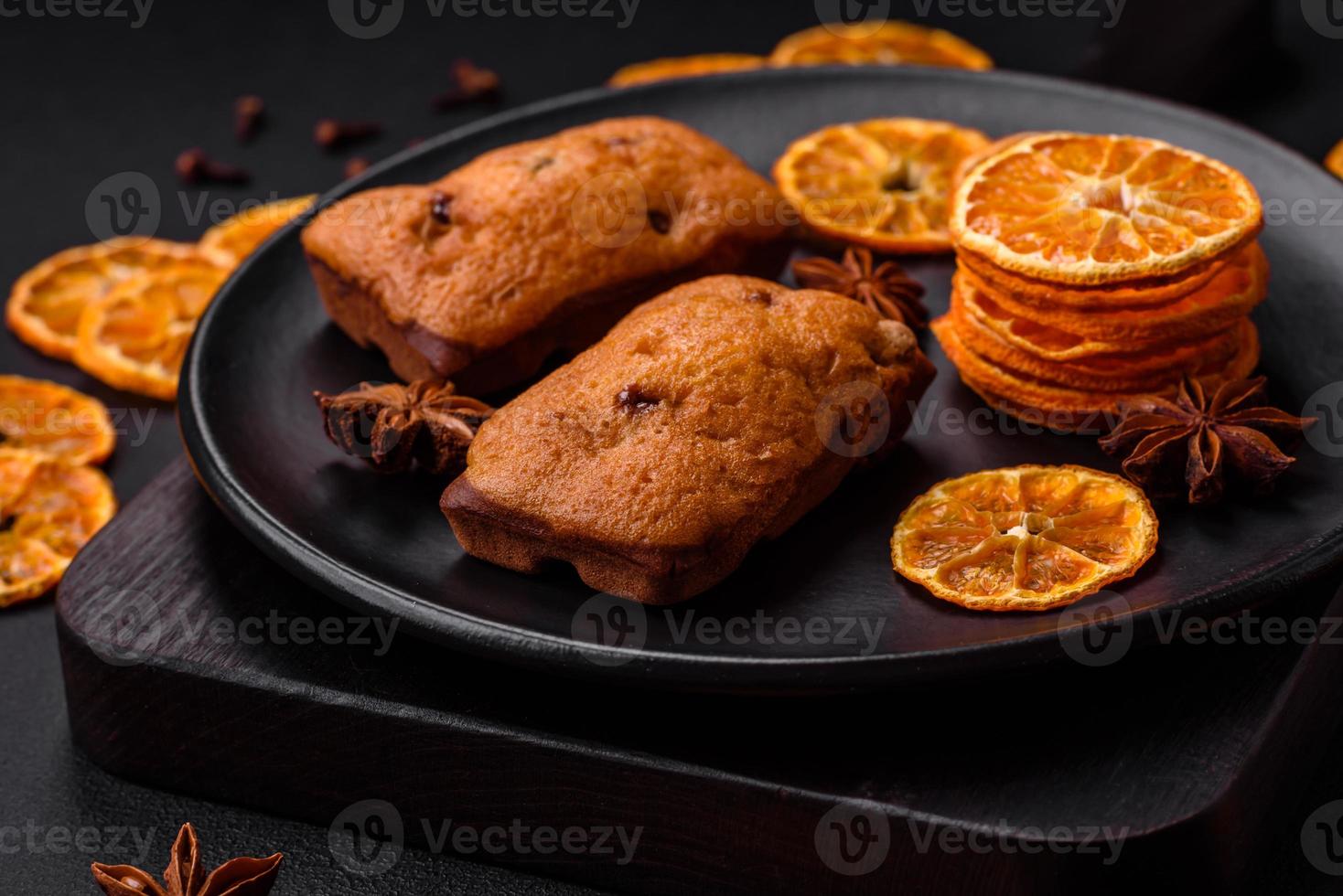 Delicious chocolate muffins and dried round shaped slices of tangerine photo