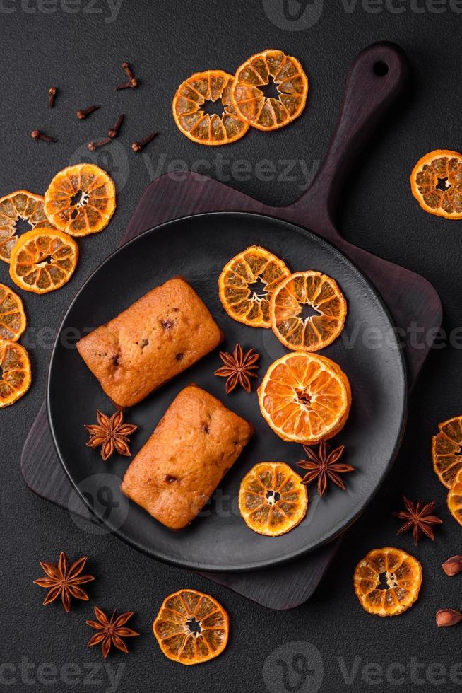 Delicious chocolate muffins and dried round shaped slices of tangerine photo