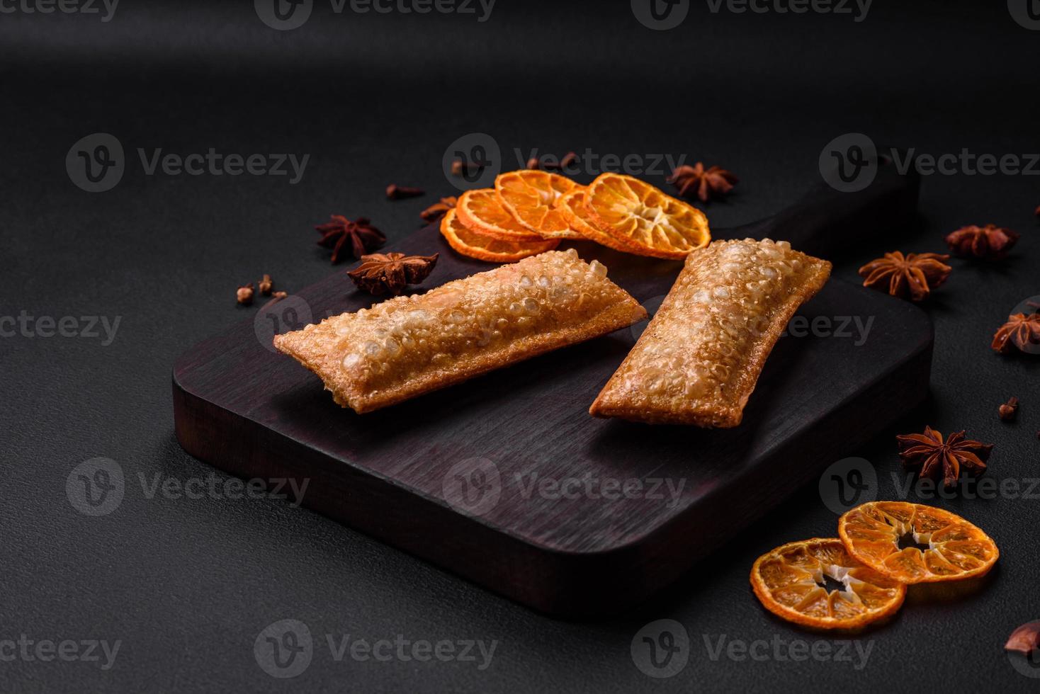 Delicious fresh crispy pie with cherry jam on a wooden cutting board photo