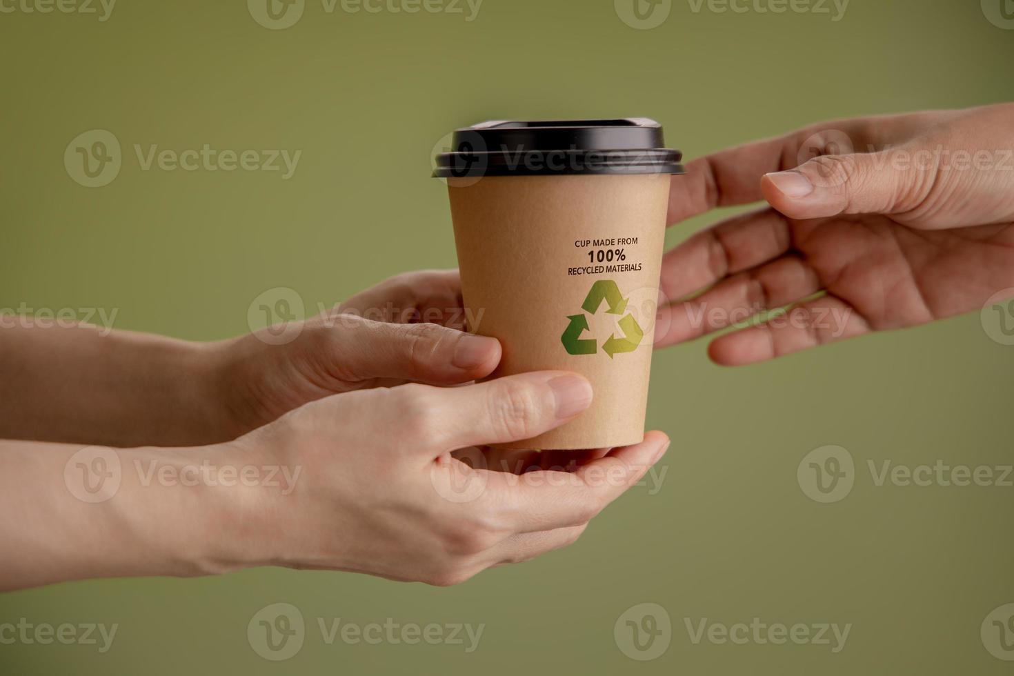 Recycled Packaging Concept. Closeup of Barista  Giving a Hot Cup of Coffee to customer. Zero Waste Materials. Environment Care, Reuse, Renewable for Sustainable Lifestyle photo