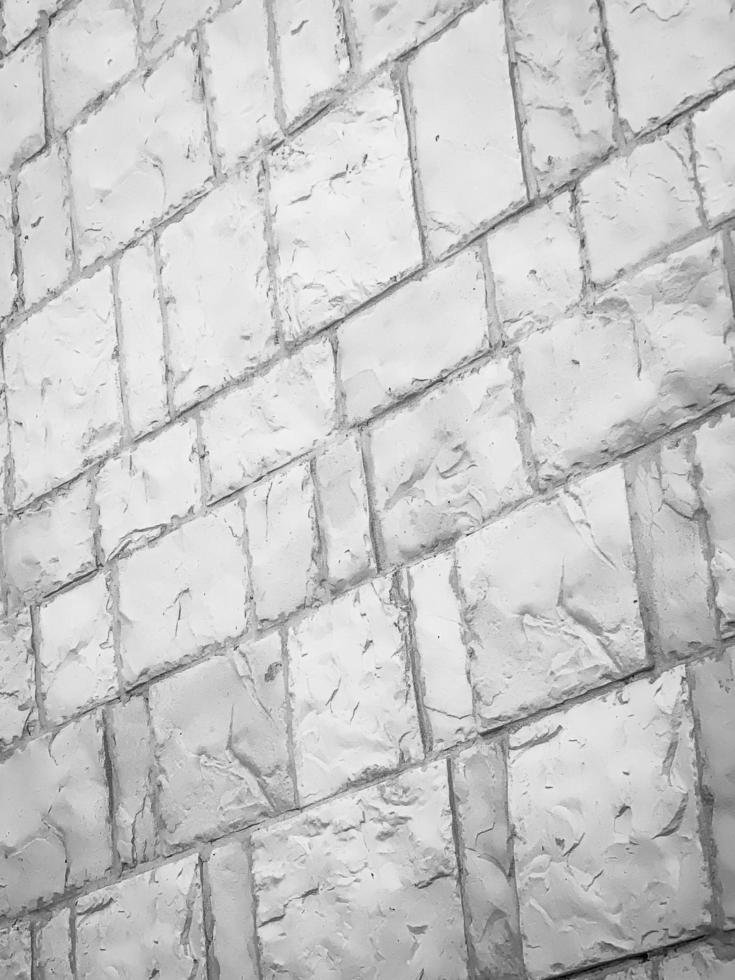 A white brick wall, The bricks are uniform in size and shape, arranged in a traditional brick bond pattern  rows offset from each other. The white color of the bricks gives the wall a modern look photo