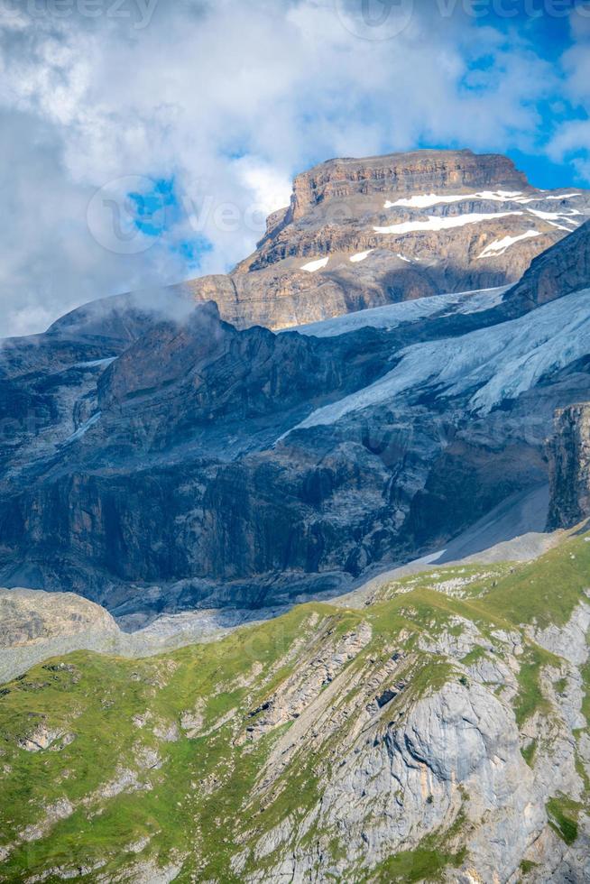 Mountain panorama under cloudy sky, the sun rays illuminate the mountain photo