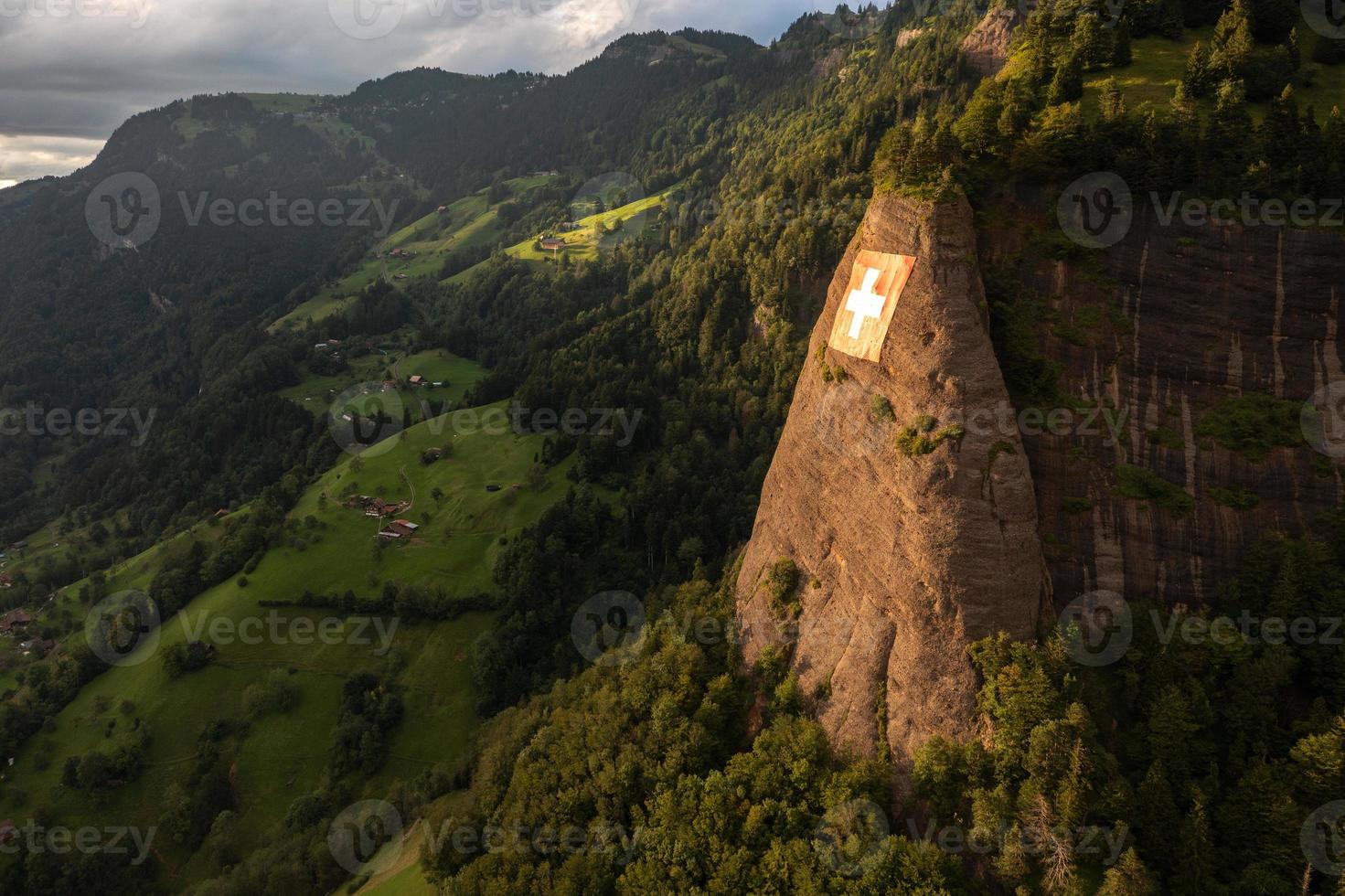 a huge swiss flag is fixed on a cliff photo