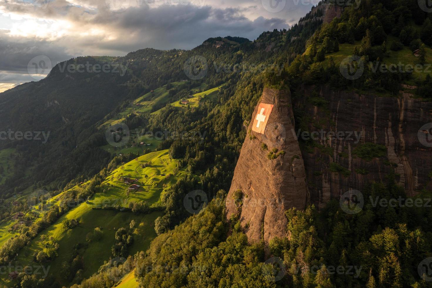 a huge swiss flag is fixed on a cliff photo