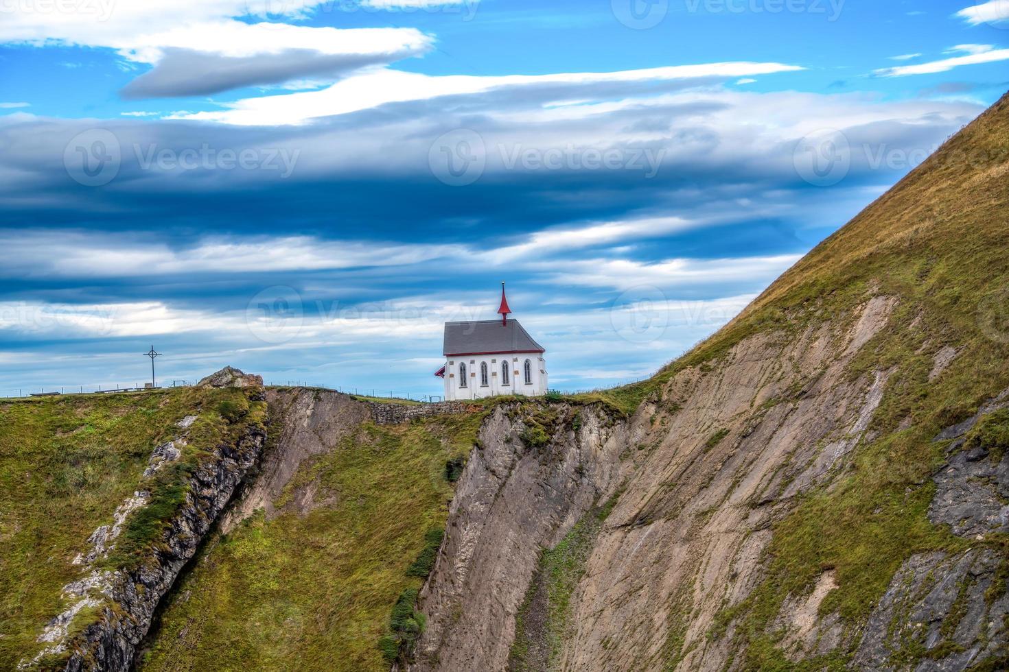 A chapel that stands on a mountain photo