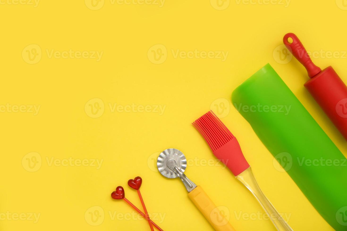 culinary accessories on a yellow background, rolling pin, brush, silicone mat, dough knife, skewers, culinary background photo