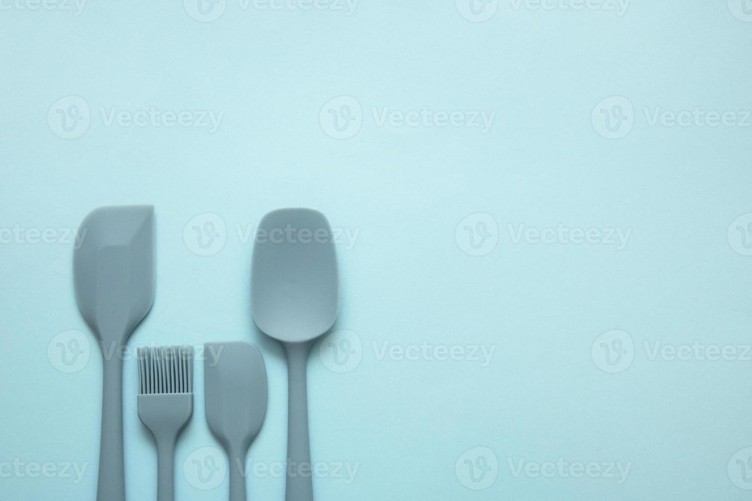 culinary silicone spatulas of different sizes and shapes and a silicone brush on a blue background, culinary background photo