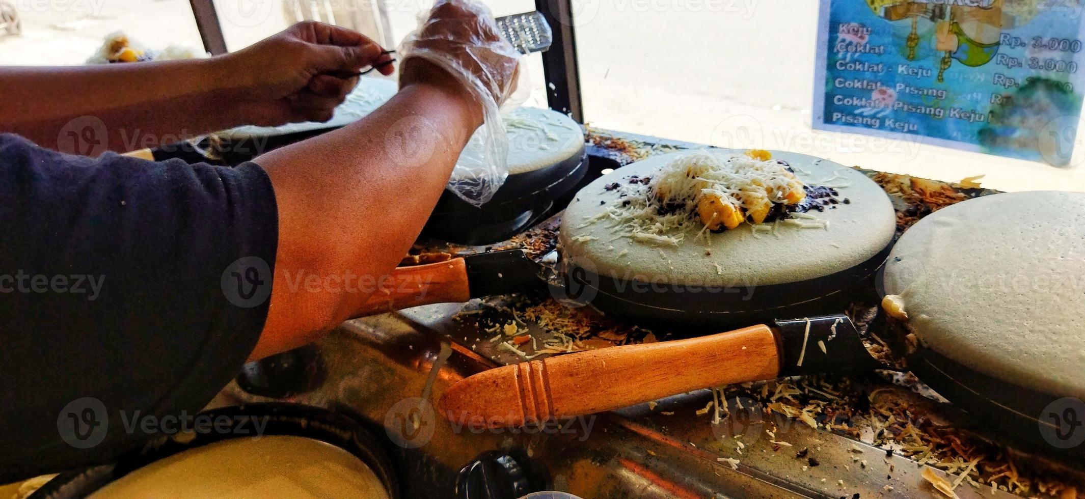 Surakarta, Indonesia, March 12, 2023. Kue leker is a type of Indonesian crepe street food, made with flour, eggs, milk and sugar with various fillings such as banana, chocolate and cheese. Crispy. photo